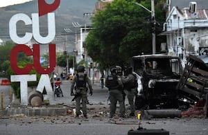 Agentes de Policía inspeccionan los restos de un camión tras la explosión de un carro bomba en Cúcuta.