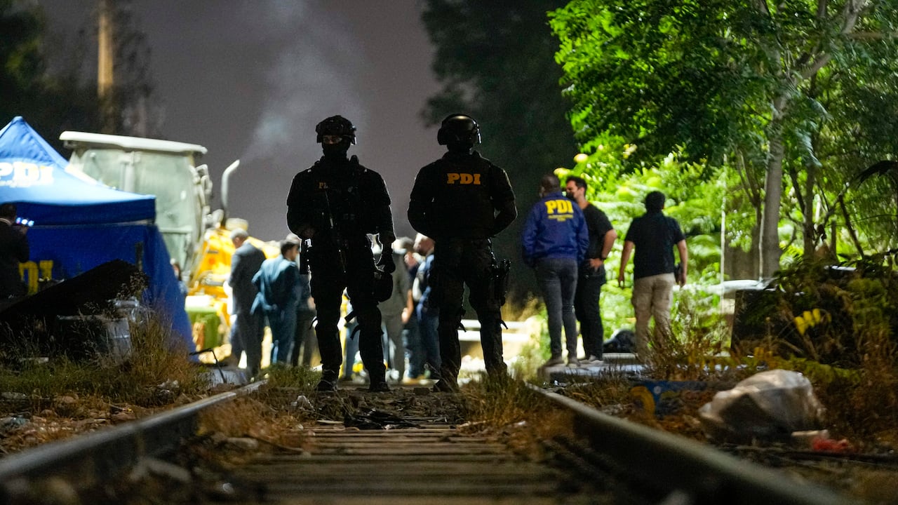 Policías e investigadores forenses trabajan en el área donde fue hallado el cadáver del ex militar venezolano Roland Ojeda, el 1 de marzo de 2024, en Santiago, Chile. (AP Foto/Esteban Félix)