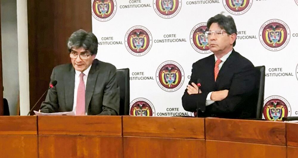 El presidente de la Corte Constitucional, magistrado Antonio José Lizarazo, y el ponente de la decisión, Alejandro Linares, en la lectura de la sentencia que deja a Uribe en calidad de imputado. 