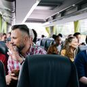 Una pareja madura sentada en un autobús saluda a sus amigos cuando se van.