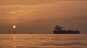 El sol sale tras varios petroleros fondeados en el estrecho de Ormuz en la costa de la isla de Queshm, Irán.