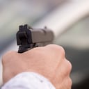 Una mano sosteniendo un arma robo atraco