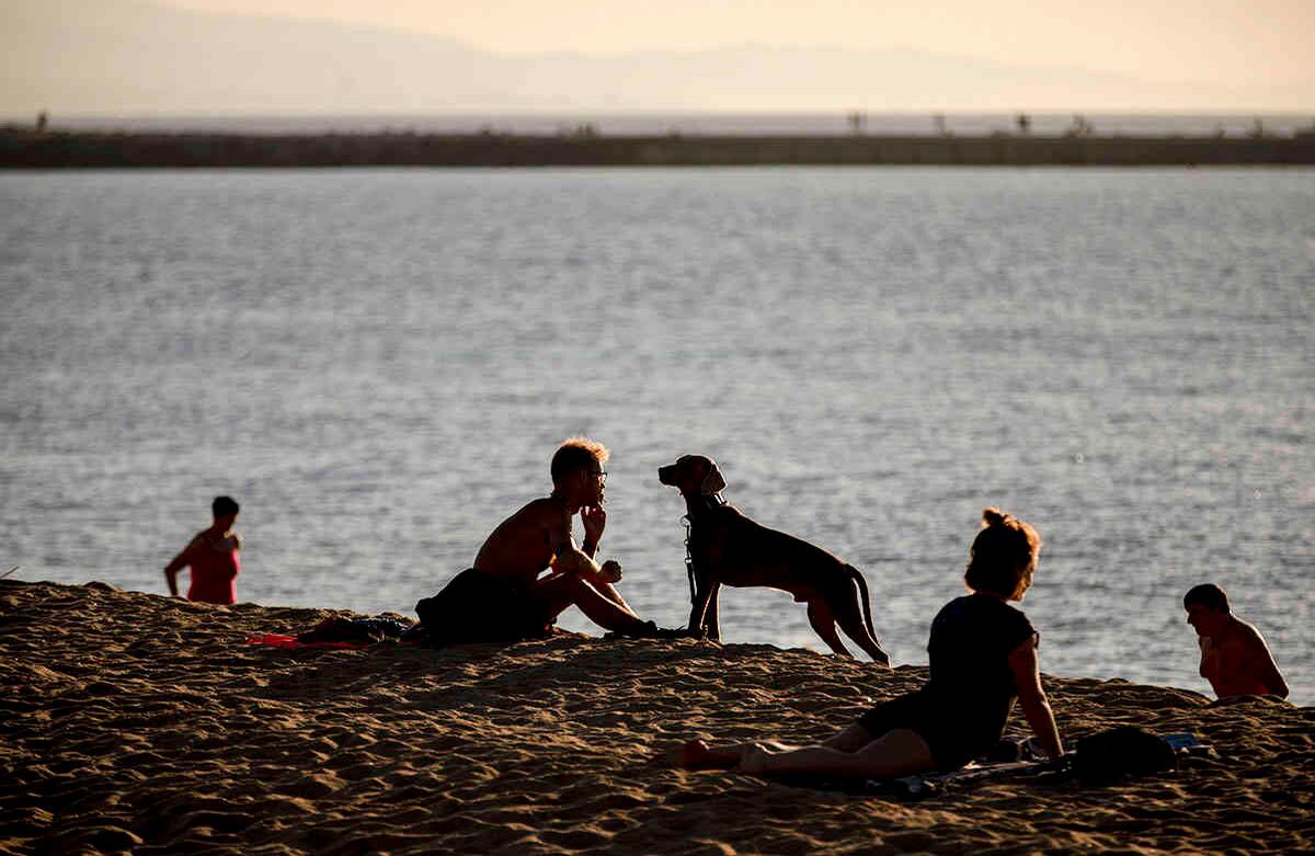 La gente disfruta de la playa en Barcelona, España, miércoles 20 de mayo de 2020. Barcelona permitió a las personas a caminar en sus playas por primera vez desde el inicio del encierro hace más de dos meses. (Foto AP / Emilio Morenatti)