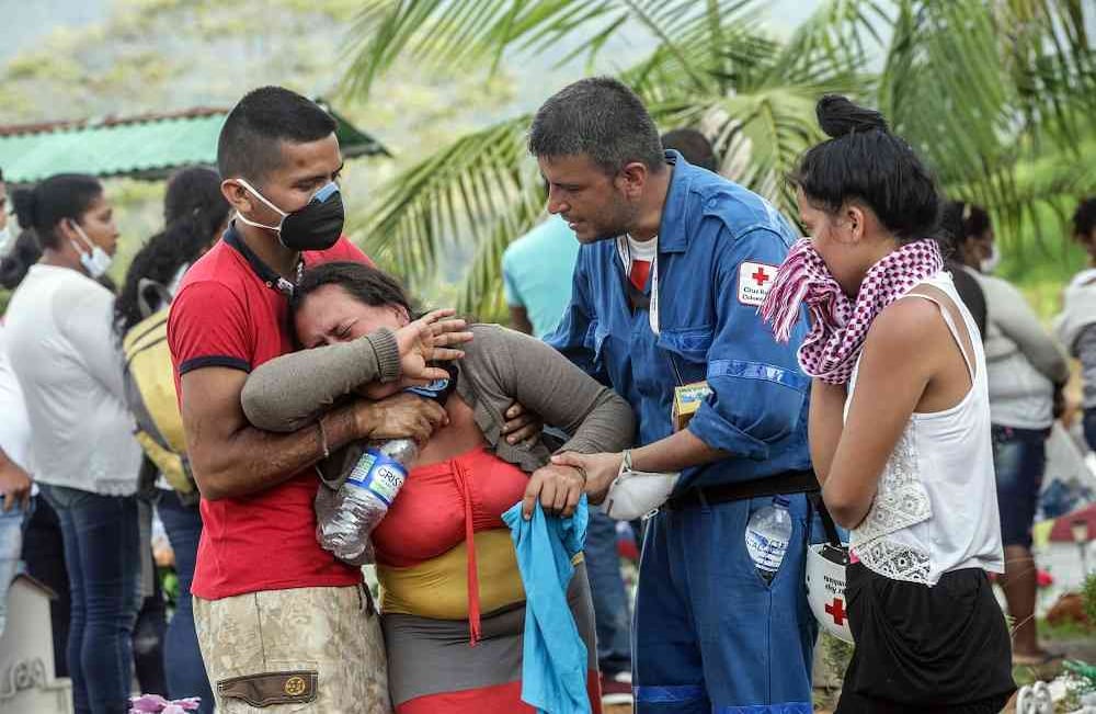 Miembros del Ejército y la Cruz Roja intentan calmar a una mujer durante la jornada de exequias en Mocoa, Putumayo. Foto: Carlos Julio Martínez / Enviado Especial de Semana