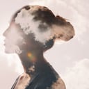 Psicología y concepto de salud mental de la mujer. Nubes de exposición múltiple y sol en la silueta de la cabeza femenina.