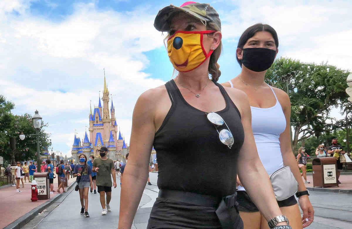 Los invitados usan máscaras, según sea necesario para asistir a la oficial reapertura del Magic Kingdom en Walt Disney World en Lake Buena Vista, Florida, el sábado 11 de julio de 2020. Disney reabrió dos parques de Florida, el Magic Kingdom y Animal Kingdom, el sábado, con capacidad limitada y protocolos de seguridad establecidos en respuesta a la pandemia de coronavirus.