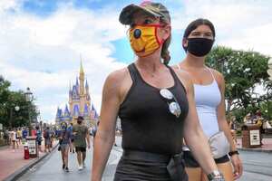 Los invitados usan máscaras, según sea necesario para asistir a la oficial reapertura del Magic Kingdom en Walt Disney World en Lake Buena Vista, Florida, el sábado 11 de julio de 2020. Disney reabrió dos parques de Florida, el Magic Kingdom y Animal Kingdom, el sábado, con capacidad limitada y protocolos de seguridad establecidos en respuesta a la pandemia de coronavirus.