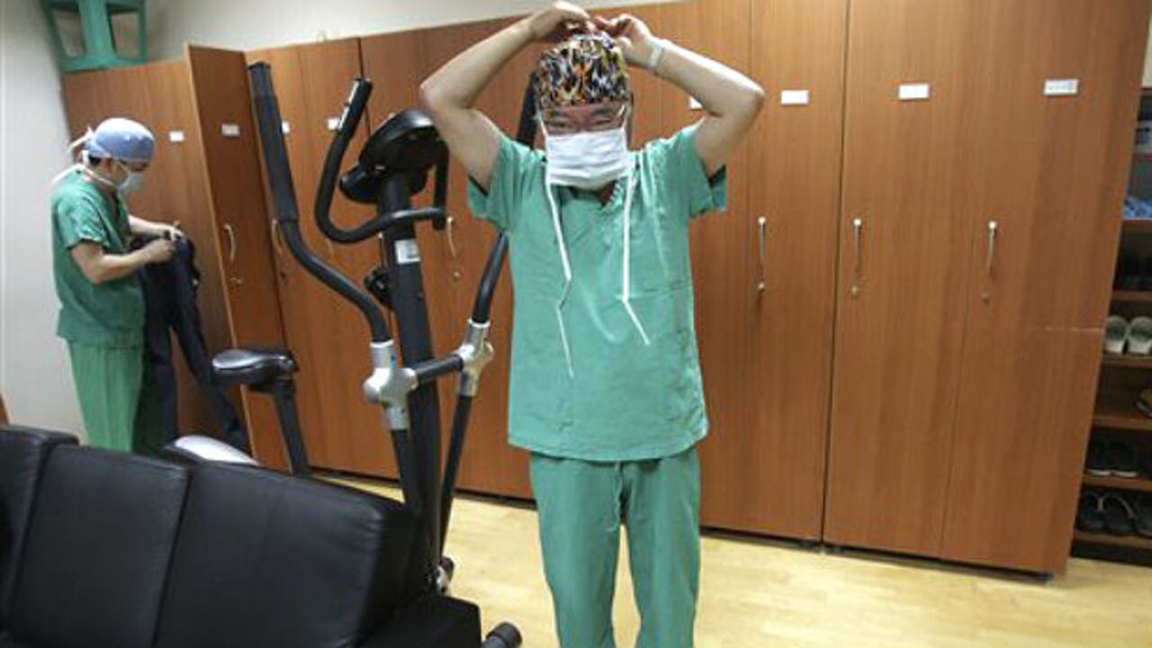 El Dr. Kim Seok-Kwun se alista para entrar a un quirófano en el Hospital Universitario de Dong-A, en Corea del Sur. Kim es un pionero en cirugías de cambio de sexo en su país, donde el tema es tabú.