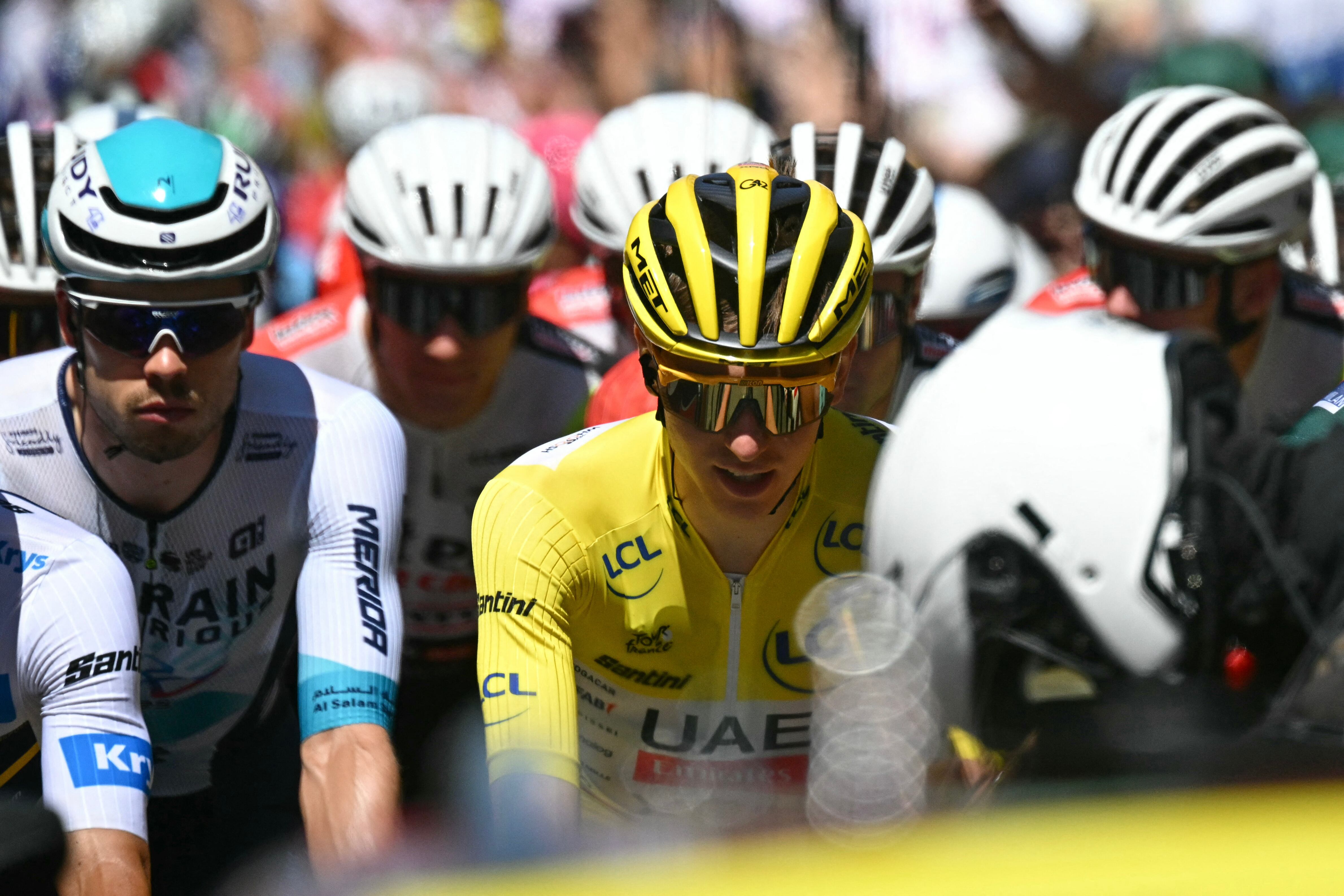Bahrain - Victorious team's German rider Phil Bauhaus (L) and UAE Team Emirates - XRG team's Slovenian rider Tadej Pogacar wearing the overall leader's yellow jersey (C) cycle at the start of the 6th stage of the 112th edition of the Tour de France cycling race, 201.5 km between Bayeux and Vire Normandie, Northwestern France on July 10, 2025. (Photo by Loic VENANCE / AFP)