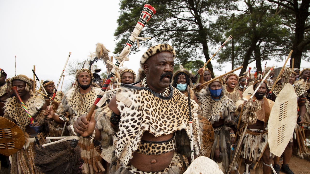 Amabutho (Zulu regiments) make their way to the mortuary to receive the body of King Goodwill Zwelithini from in Nongoma, KwaZulu Natal on March 17, 2021. - King Goodwill Zwelithini died on March 12, 2021 in the eastern city of Durban, aged 72, after weeks of treatment for a diabetes-related illness.
His remains have been taken back to his birthplace, the small southeastern town of Nongoma in Kwa-Zulu Natal province, where he will be laid to rest after midnight.
The intimate ceremony, to be conducted behind closed doors at the KwaKhethomthandayo royal residence, is referred to as a "planting" rather than a burial. (Photo by Phill Magakoe / AFP)