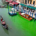 Una góndola navega por el histórico Gran Canal de Venecia, manchado por el líquido verde, el domingo 28 de mayo de 2023.