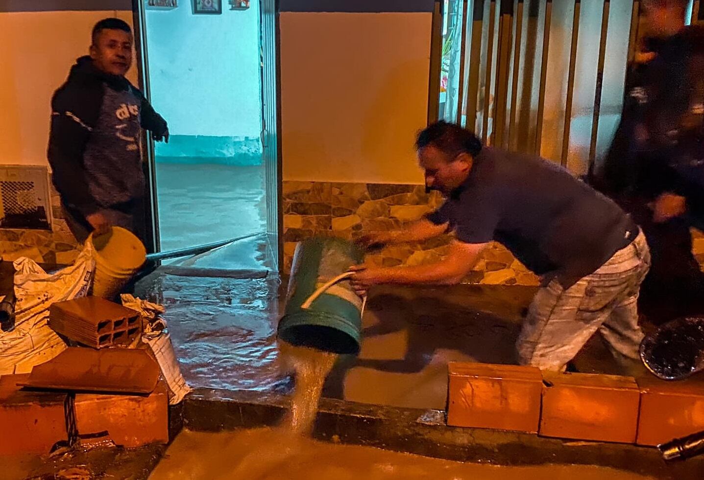 Con baldes tuvieron que sacar el agua de las casas en Toro, Valle del Cauca, tras las lluvias.