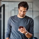 Varón joven profesional mediante teléfono móvil en la oficina