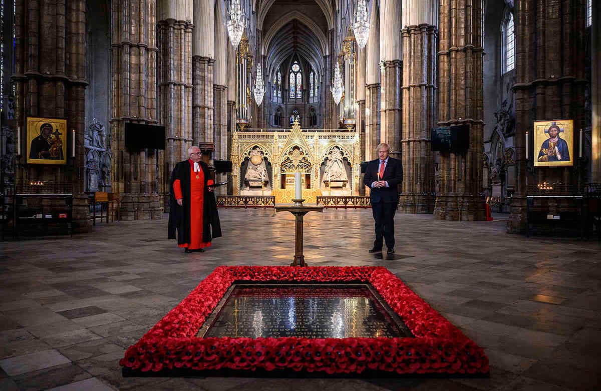 El decano de Westminster, reverendísimo doctor David Hoyle, lee una oración mientras el primer ministro británico, Boris Johnson, sostiene una vela encendida ante en la Tumba del Guerrero Desconocido, en la Abadía de Westminster, en Londres. 7 de mayo. Europa conmemoró esta semana el 75º aniversario del Día de la Victoria. Foto: Leon Neal/Pool vía AP