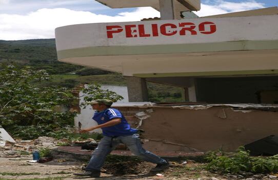 Algunas personas arriesgan sus vidas para recuperar bloques de ladrillo de las ruinas.