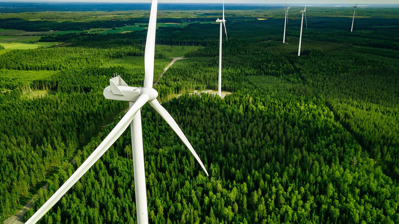 Vista aérea de molinos de viento en bosque verde de verano en Finlandia. Aerogeneradores para energía eléctrica con Energías Limpias y Renovables