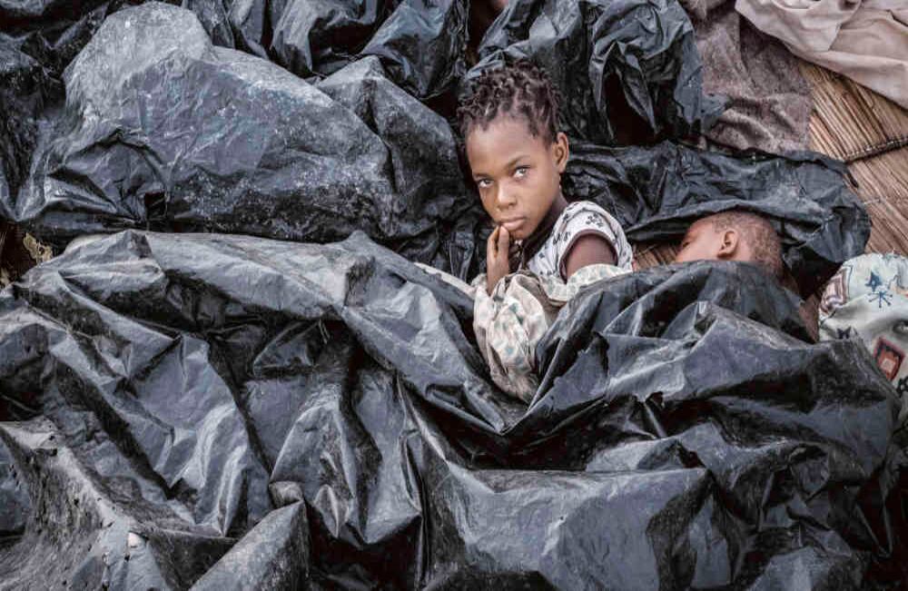 Triste despertar: Enia Joaquín Luis, de 11 años, se despierta debajo de sábanas de plástico para protegerse de la lluvia en Mozambique, el 23 de marzo. 417 personas murieron en el país después de que un ciclón azotó varias regiones y provocó inundaciones. Cientos de personas perdieron sus casas y las enfermedades se expandieron rápidamente. El país no ha podido levantarse de la crisis humanitaria que causó el desastre natural. Foto: Yasuyoshi Chiba / AFP
