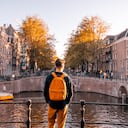 Vista trasera de un hombre mirando el canal de Ámsterdam en un día soleado, Países Bajos