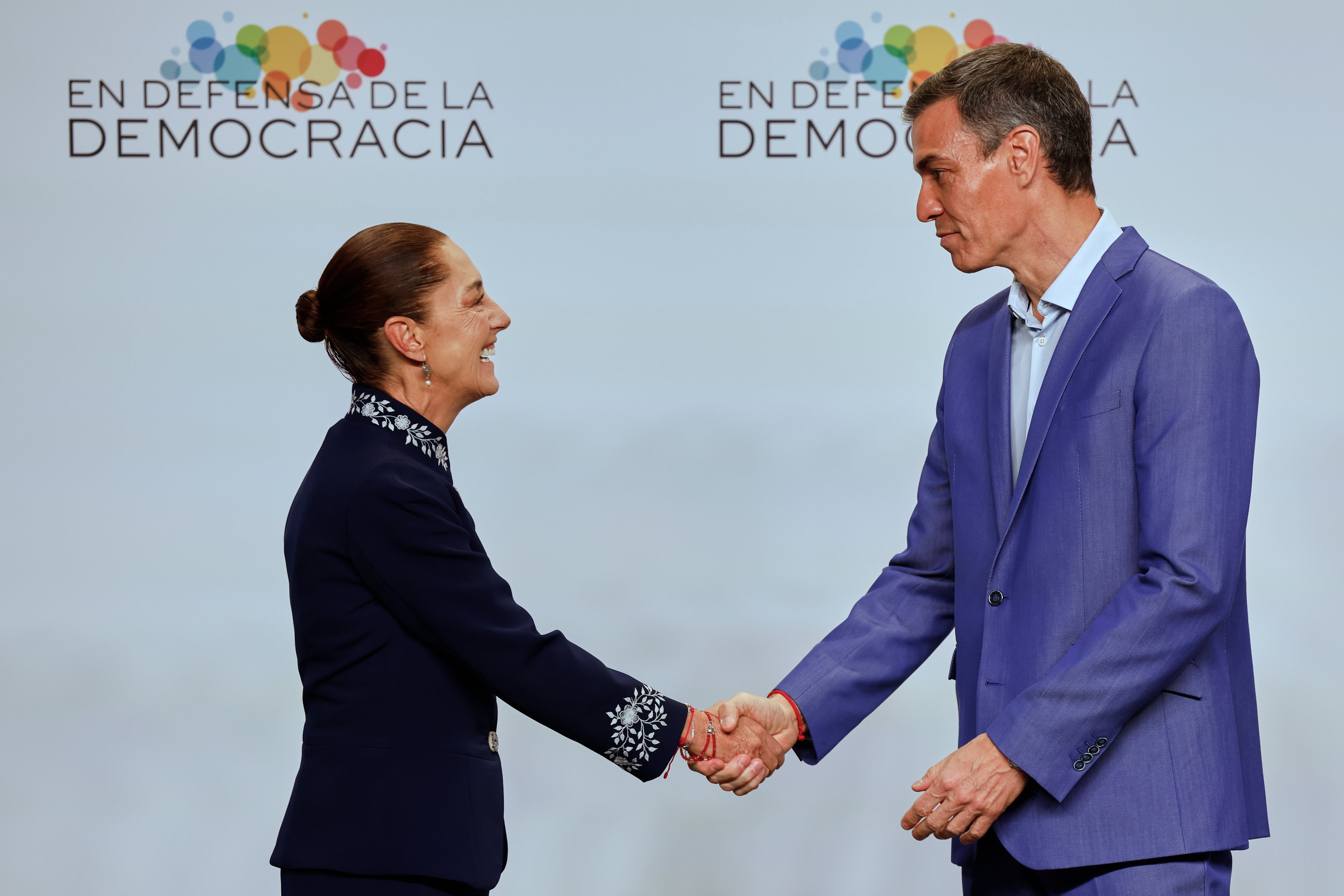 El presidente del gobierno de España, Pedro Sánchez, estrecha la mano de la presidenta de México, Claudia Sheinbaum, en la Reunión en Defensa de la Democracia, en Barcelona.
