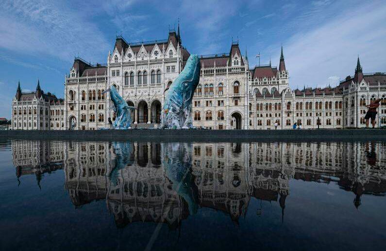 Esculturas de ballenas hechas de desechos plásticos que se recuperaron del océano están en exhibición en el edificio del parlamento en Budapest, Hungría, el martes 9 de julio de 2019. La instalación temporal fue erigida por Greenpeace como parte del movimiento ambiental internacional Julio Libre, para protestar contra la contaminación por plástico de los océanos del mundo. (Zsolt Szigetvary / MTI a través de AP)