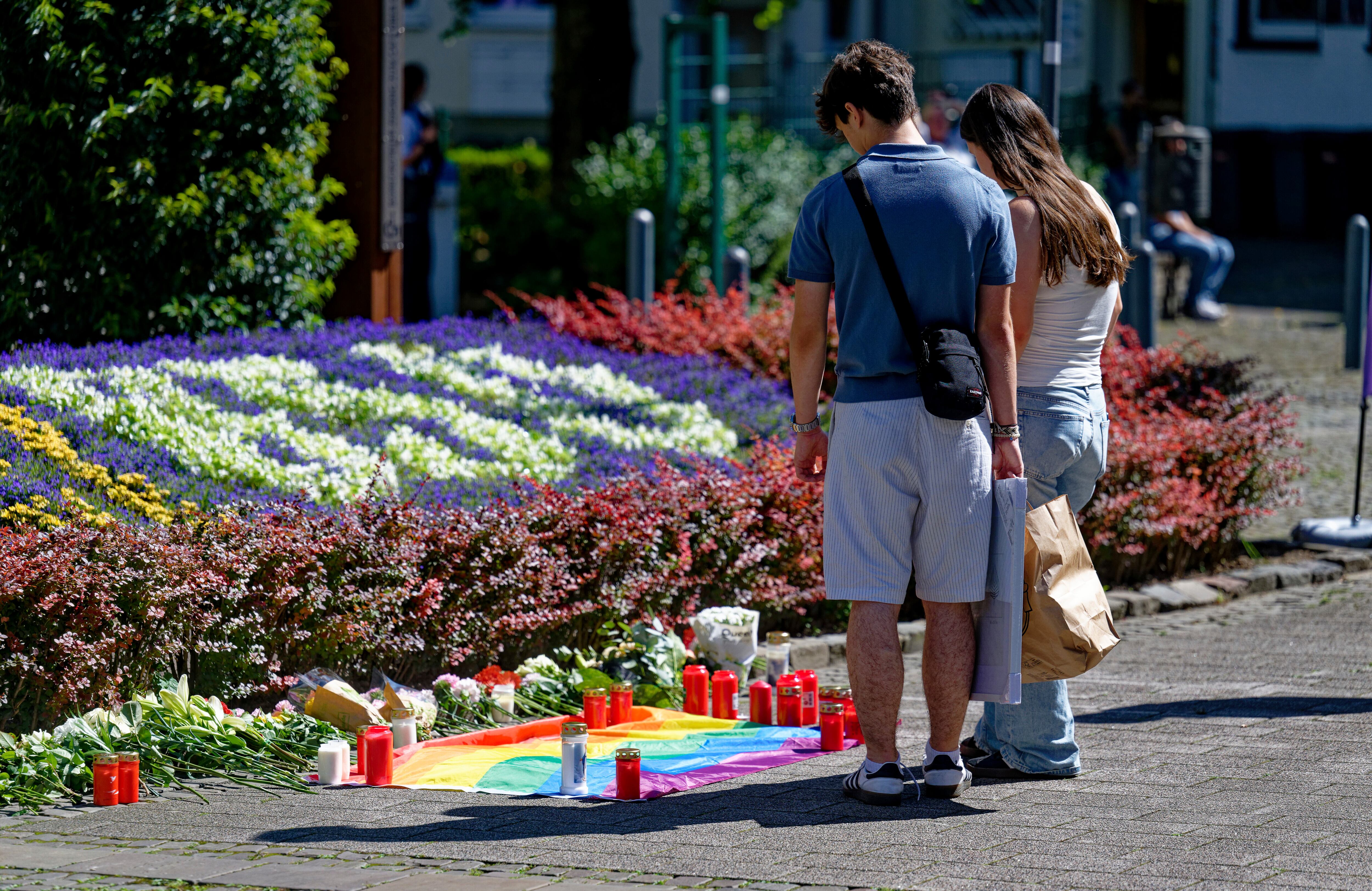La gente deposita flores cerca del lugar de un ataque con cuchillo en el centro de la ciudad de Solingen, Alemania, el sábado 24 de agosto de 2024, después de que tres personas murieran y al menos ocho resultaran heridas el viernes por la noche en el festival. (Henning Kaiser/dpa vía AP)