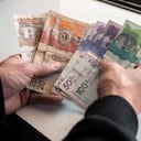 Men's hands with Colombian Pesos