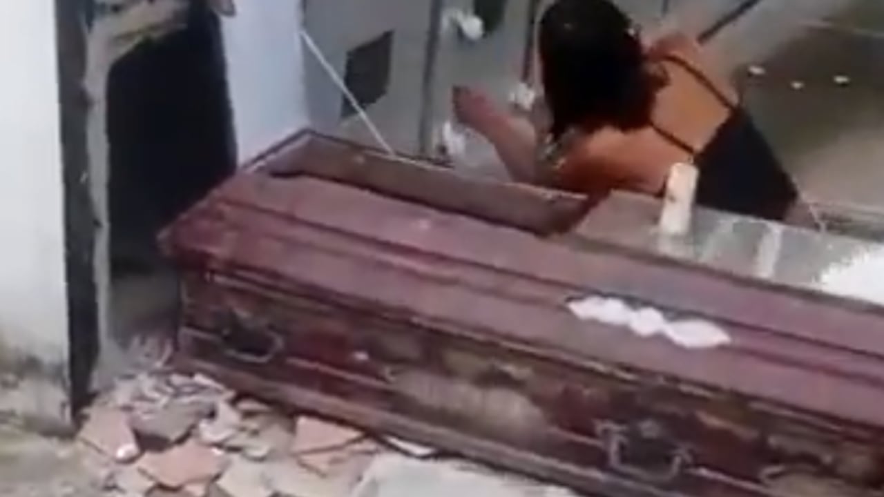 La mujer, mientras profanaba la tumba de Diego Expedito Moreno.