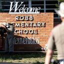 UVALDE, TX - MAY 25: A Texas State Trooper receives flowers for the victims of a mass shooting yesterday at Robb Elementary School where 21 people were killed, including 19 children, on May 25, 2022 in Uvalde, Texas. The shooter, identified as 18-year-old Salvador Ramos, was reportedly killed by law enforcement. (Photo by Jordan Vonderhaar/Getty Images)