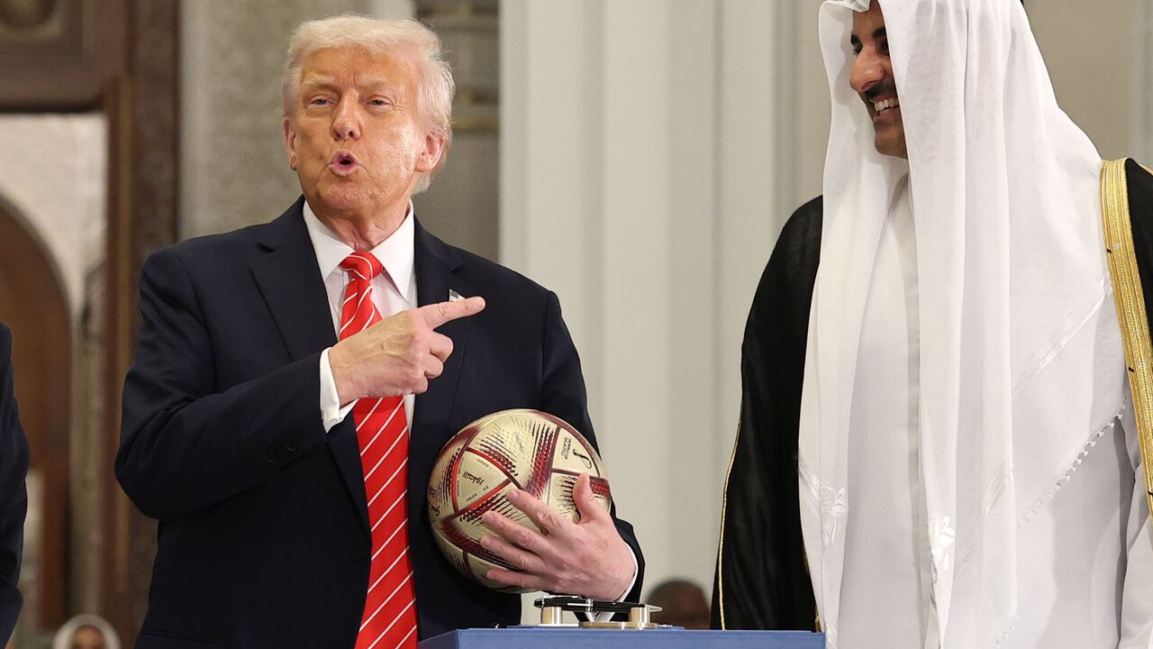 DOHA, QATAR – 14 DE MAYO: (De izquierda a derecha) El presidente estadounidense Donald J. Trump y el emir de Qatar Tamim bin Hamad al Thani firman una pelota de fútbol durante una ceremonia de la Copa Mundial 2026 después de una cena de estado en el Palacio Lusail el 14 de mayo de 2025, en Doha, Qatar