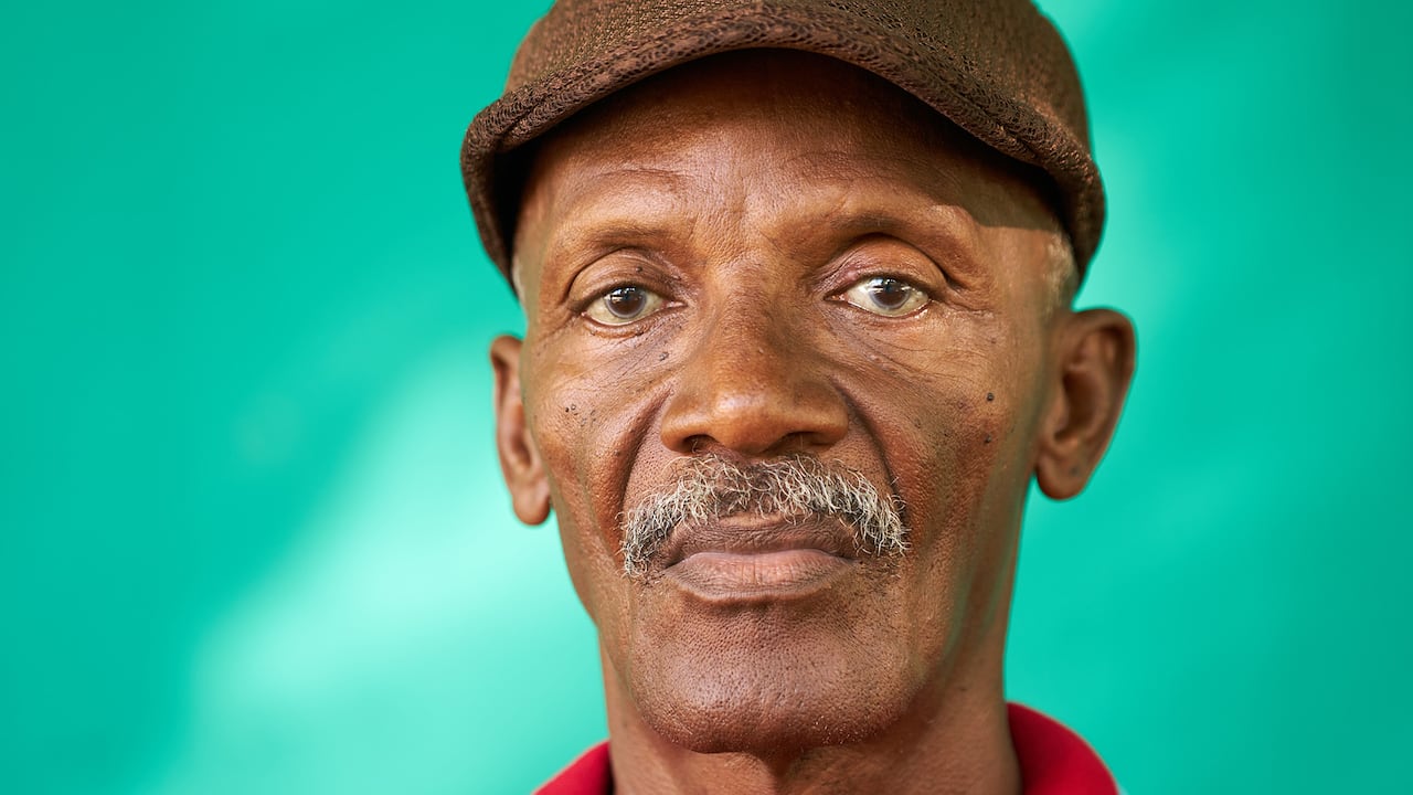 Verdadero pueblo cubano y sentimientos, retrato de hombre afroamericano senior triste mirando a cámara. Abuelo latino viejo preocupado con bigote y sombrero de La Habana, Cuba