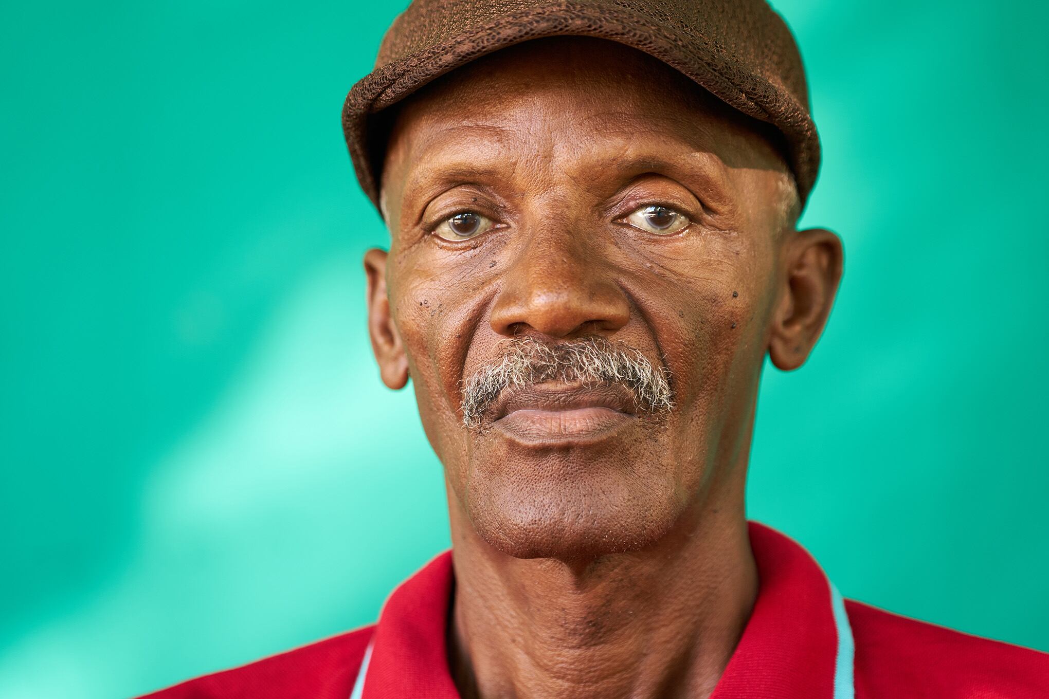 Verdadero pueblo cubano y sentimientos, retrato de hombre afroamericano senior triste mirando a cámara. Abuelo latino viejo preocupado con bigote y sombrero de La Habana, Cuba