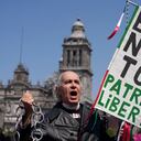 Un manifestante antigubernamental vestido como el héroe de la independencia Miguel Hidalgo, sostiene un cartel que dice en español "No toques INE, Patria y Libertad", durante una marcha contra las recientes reformas impulsadas por el presidente Andrés Manuel López Obrador a la ley electoral del país que dicen amenazar la democracia, en la plaza principal de la Ciudad de México, El Zócalo, el domingo 26 de febrero de 2023.