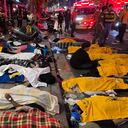 Un hombre se sienta en medio de los cuerpos de las víctimas, que se cree que sufrieron un paro cardíaco, en el popular distrito de vida nocturna de Itaewon en Seúl el 30 de octubre de 2022. - Decenas de personas sufrieron un paro cardíaco en la capital de Corea del Sur. Seúl, después de que miles de personas se aglomeraran en las estrechas calles del barrio Itaewon de la ciudad para celebrar Halloween, dijeron funcionarios locales. (Foto de Yelim LEE / AFP)