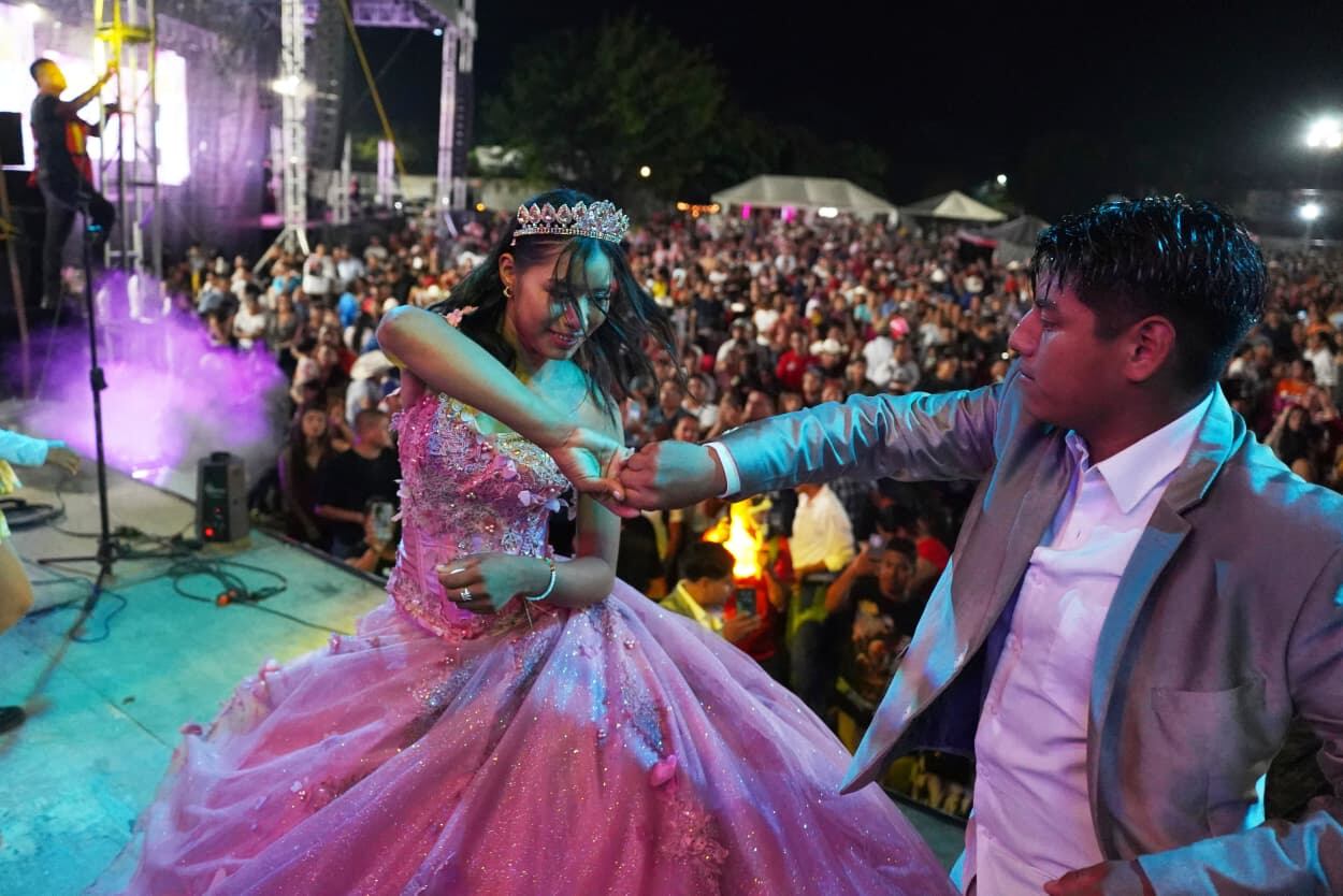 Quinceañera con vestido rosa bailando en un estadio lleno de público en San Luis Potosí.