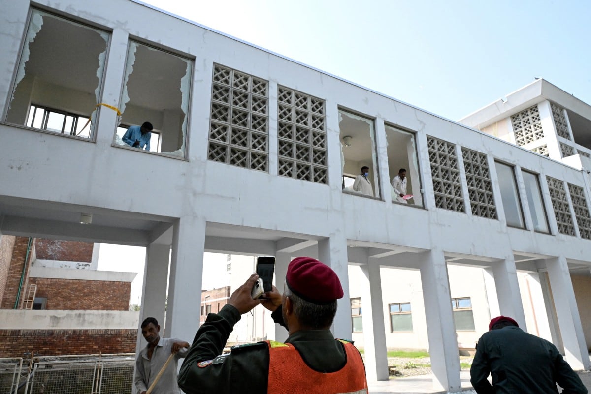 Trabajadores retiran fragmentos de ventanas rotas tras un incendio ocurrido el 26 de agosto de 2026 en las afueras de la sala de maternidad del Instituto Pakistaní de Ciencias Médicas (PIMS) en Islamabad.
