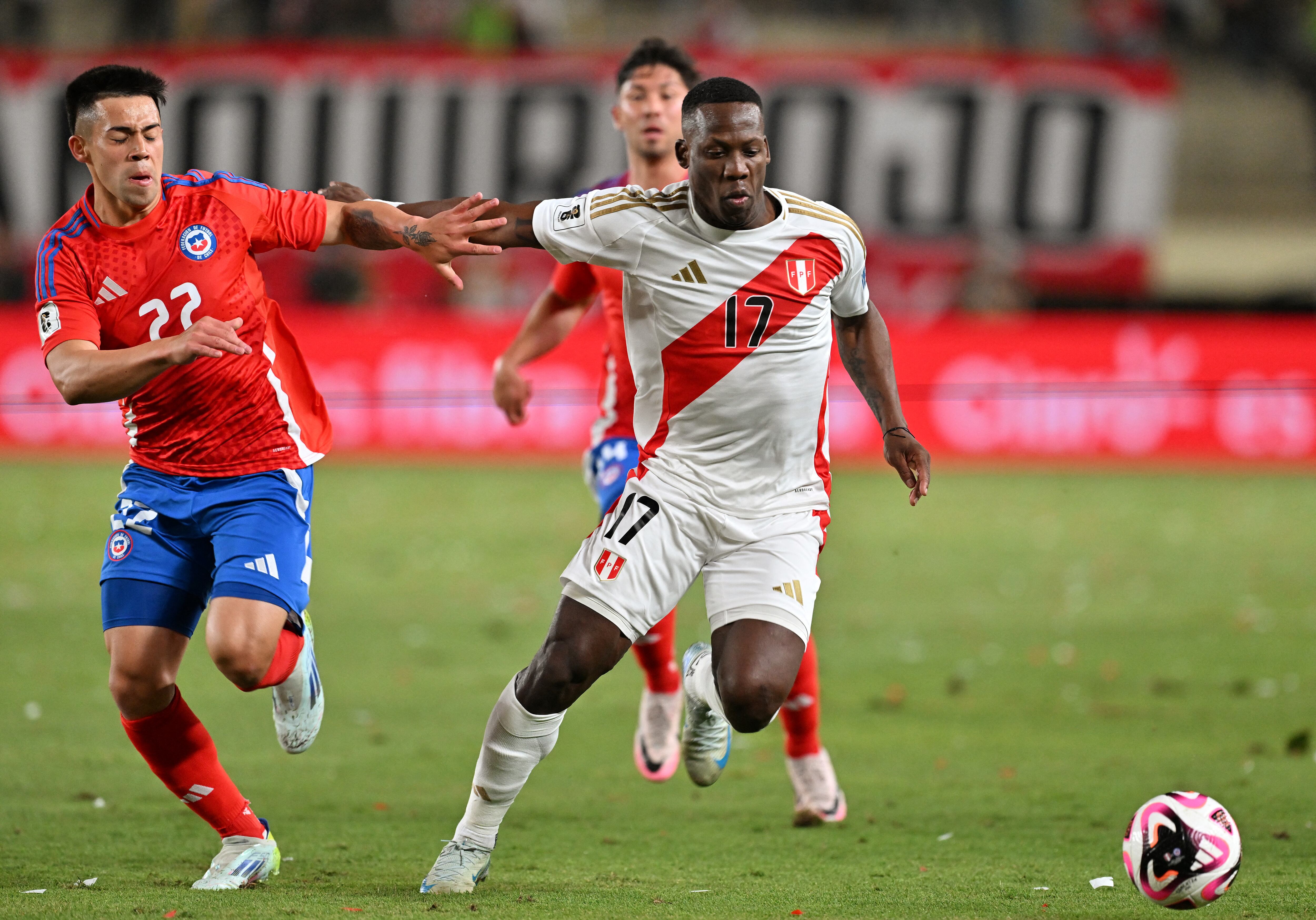 El delantero de Chile #22 Alexander Aravena Y el defensor de Perú #17 Luis Advíncula luchan por el balón durante las eliminatorias sudamericanas para la Copa Mundial de la FIFA 2026.