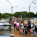 Migrantes, en su mayoría venezolanos, suben a barcos en la ciudad portuaria colombiana de Turbo, cerca del Tapón del Darién, una selva compartida por Colombia y Panamá, antes de continuar su viaje hacia Estados Unidos con la esperanza de una vida mejor, el 15 de septiembre. (Foto de Raúl ARBOLEDA / AFP)