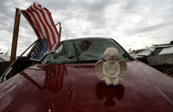 Un ángel de concreto reposa sobre un carro destrozado por el tornado que azotó a Oklahoma, en Estados Unidos. (AP)