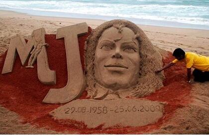 Un artista indio da los últimos retoques a una escultura de arena del cantante estadounidense Michael Jackson en la playa de Puri, cerca de Bhubaneswar, Orissa, India, con motivo del primer aniversario de la muerte del artista.