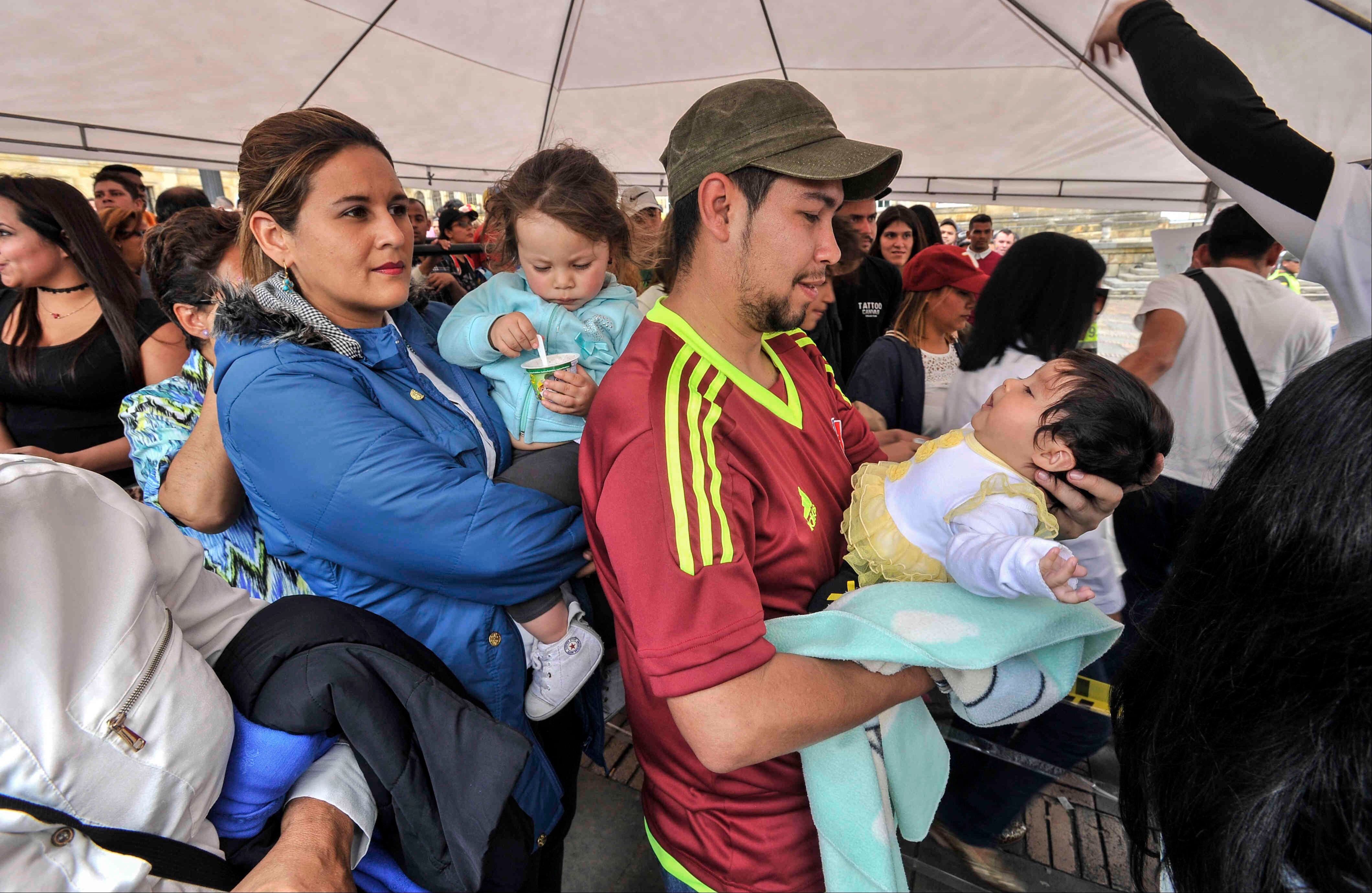 Un venezolano —residente en Bogotá—  carga un bebé mientras hace fila para sufragar,  el domingo 16 de julio de 2017, en Colombia, durante las votaciones al plebiscito. Esta jornada democrática ha sido  impulsada  por la oposición al gobierno de Nicolás Maduro. En las tarjetas, los ciudadanos deben responder ‘sí’ o ‘no’ a tres preguntas: la primera es si respalda el plan del presidente Nicolás Maduro de cambiar la Constitución; la segunda es si  apoya la intervención de las Fuerzas Armadas para “restituir el orden constitucional” y por último si desea un gobierno de unidad nacional. Foto: Carlos Julio Martínez / SEMANA