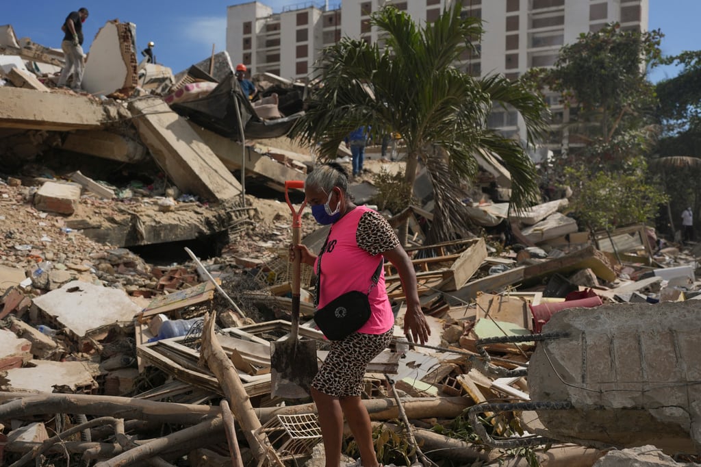 Residentes buscan entre los escombros de un edificio que se derrumbó tras los terremotos que azotaron La Guaira, Venezuela.