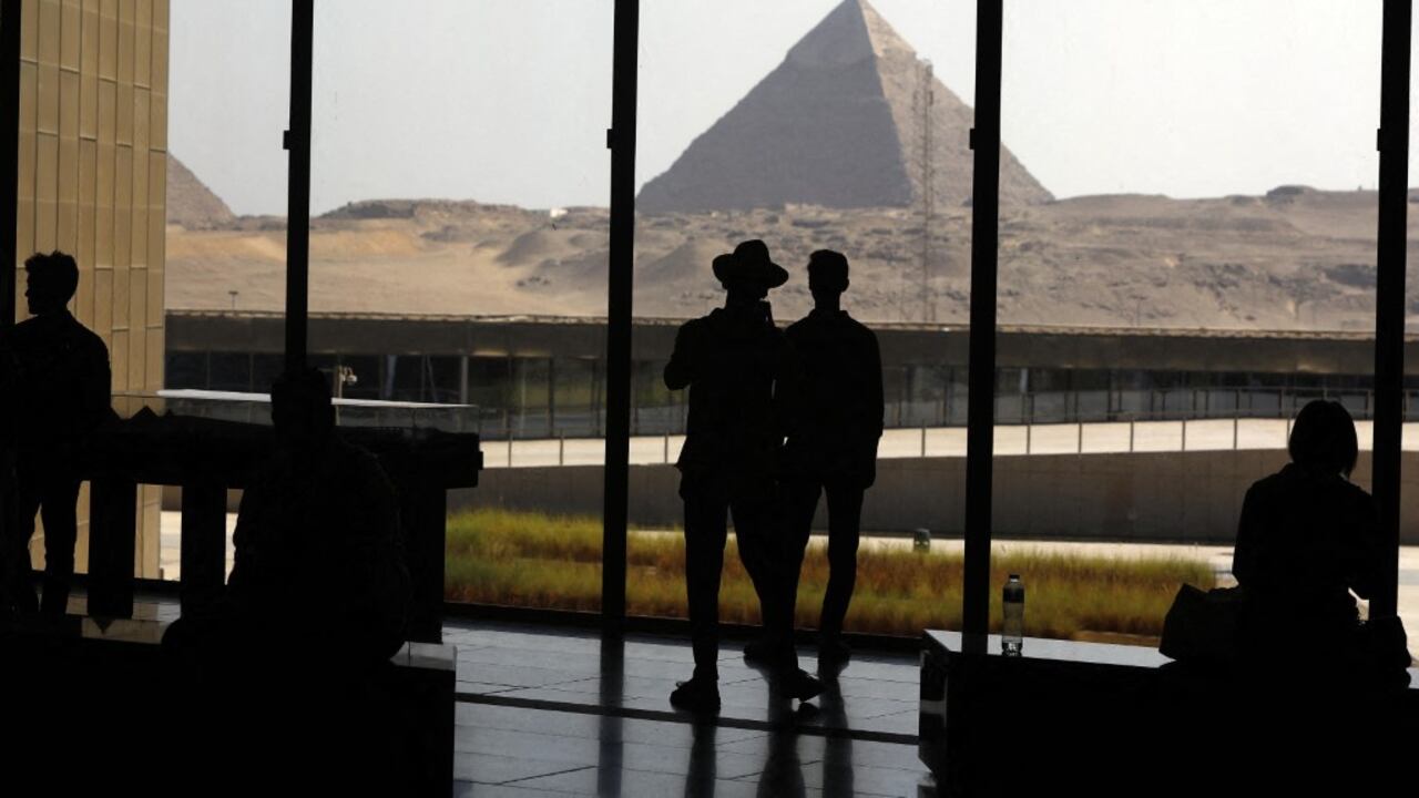 Las pirámides de Giza se ven desde el Museo Egipcio mientras los turistas visitan el museo, en Giza, Egipto, el 14 de octubre de 2025. El museo exhibe miles de artefactos de las épocas prehistórica, faraónica y romana, incluidos los tesoros de oro del rey Tutankamón, cuya tumba fue descubierta en 1922. El sitio atrae a miles de visitantes con sus doce salas de exposiciones, jardines y espacios culturales. Fareed Kotb / Anadolu (Foto de Fareed Kotb / Anadolu vía AFP)