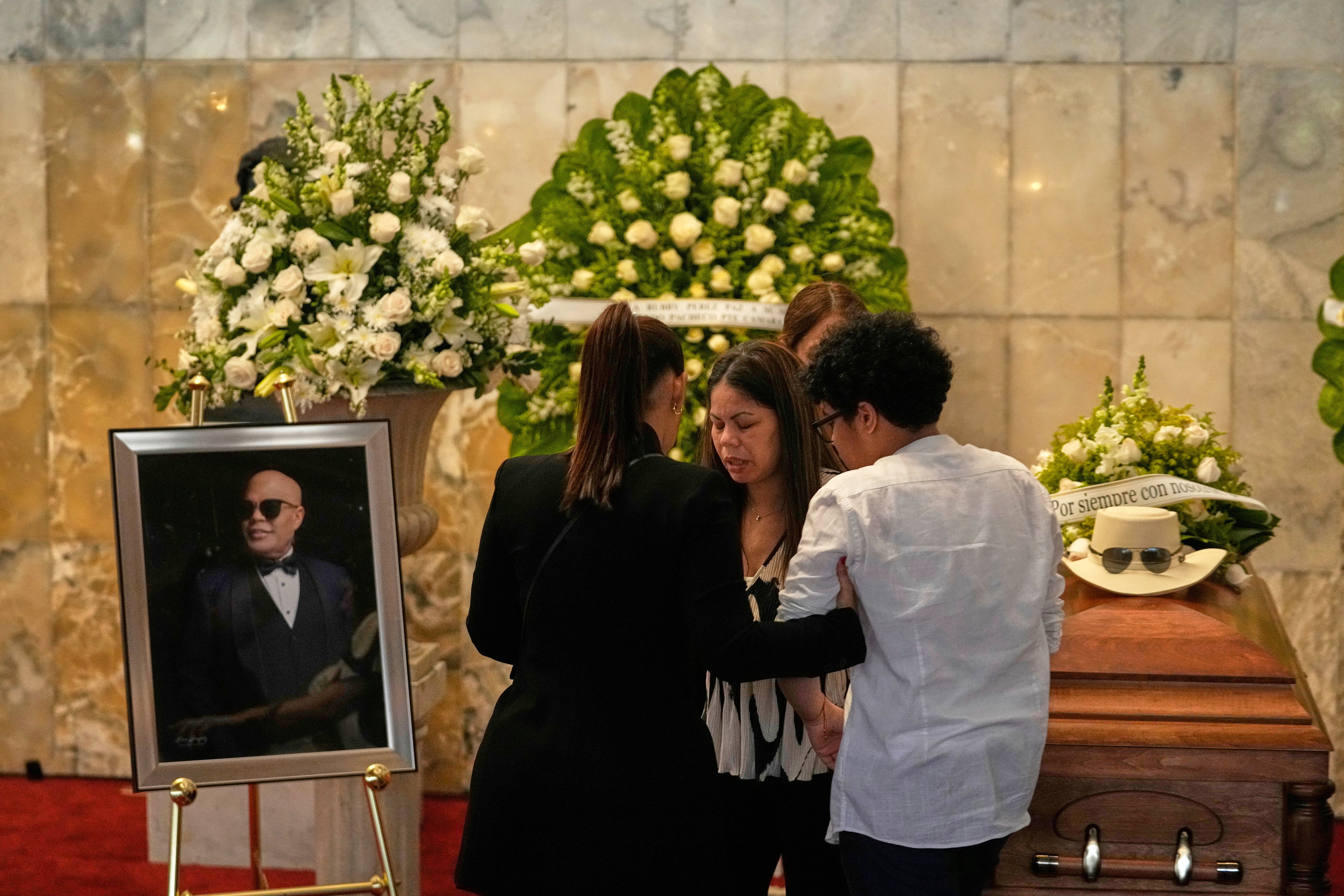 Zulinka, center, daughter of Dominican singer Rubby Perez, who died in the roof collapse at the Jet Set nightclub during his merengue concert, attends his wake at the Eduardo Brito National Theater in Santo Domingo, Dominican Republic, Thursday, April 10, 2025. (AP Photo/Matias Delacroix)