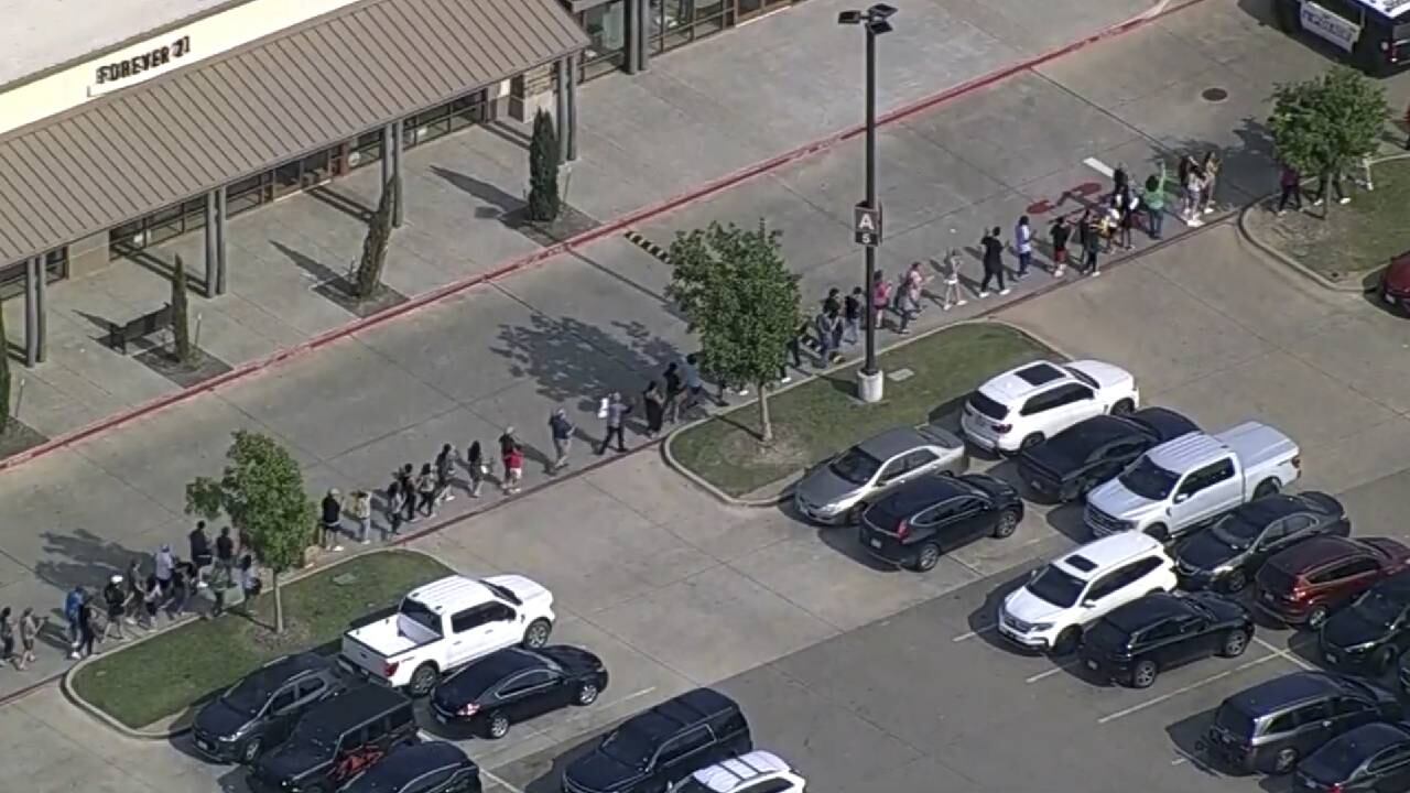 En esta captura de cuadro de un video proporcionado por WFAA, las personas son evacuadas de Allen Premium Outlet, el sábado 6 de mayo de 2023, en Allen, Texas.