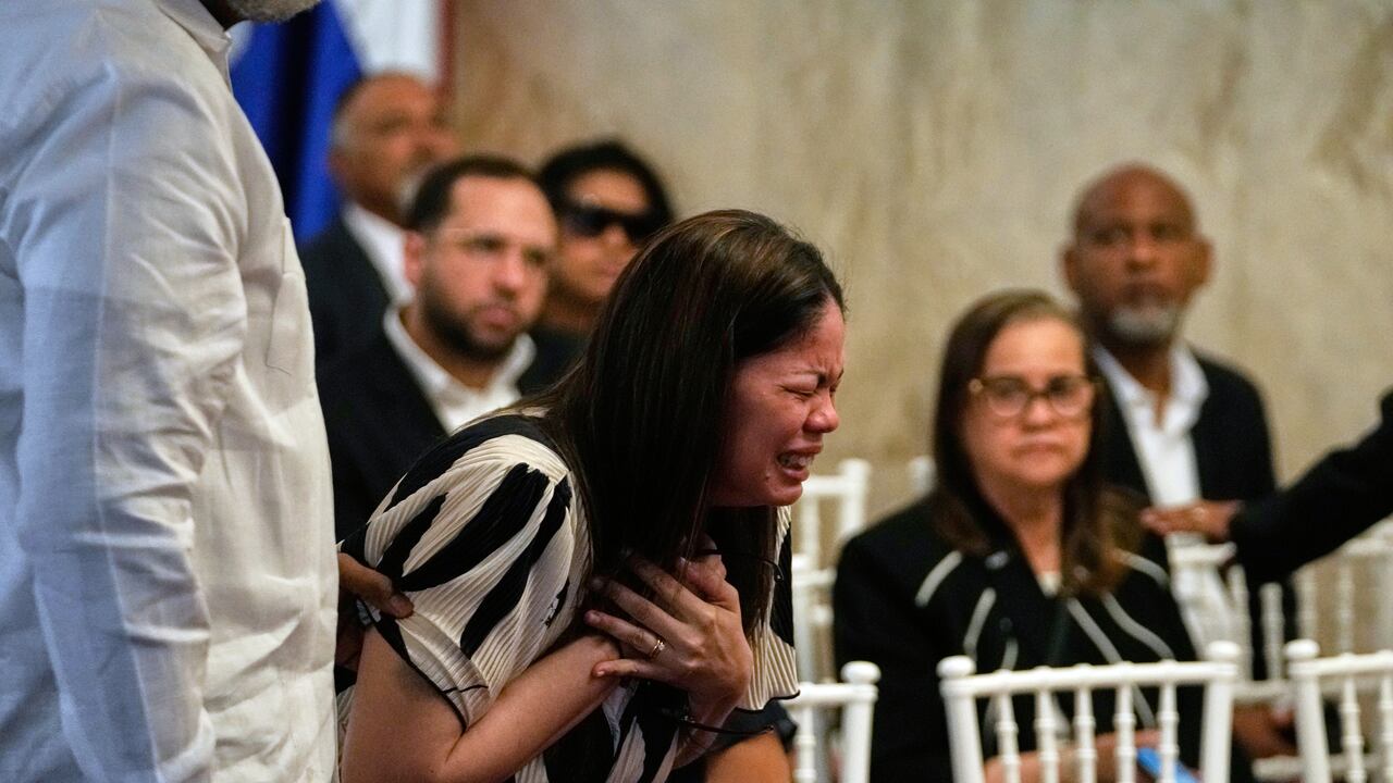 Zulinka, center, the daughter of Dominican singer Rubby Perez who died in the roof collapse at the Jet Set nightclub during his merengue concert, cries during his wake at the Eduardo Brito National Theater in Santo Domingo, Dominican Republic, Thursday, April 10, 2025. (AP Photo/Matias Delacroix)