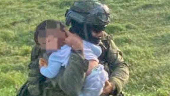 Oficial lleva en sus abrazos al menor rescatado en Pelaya.