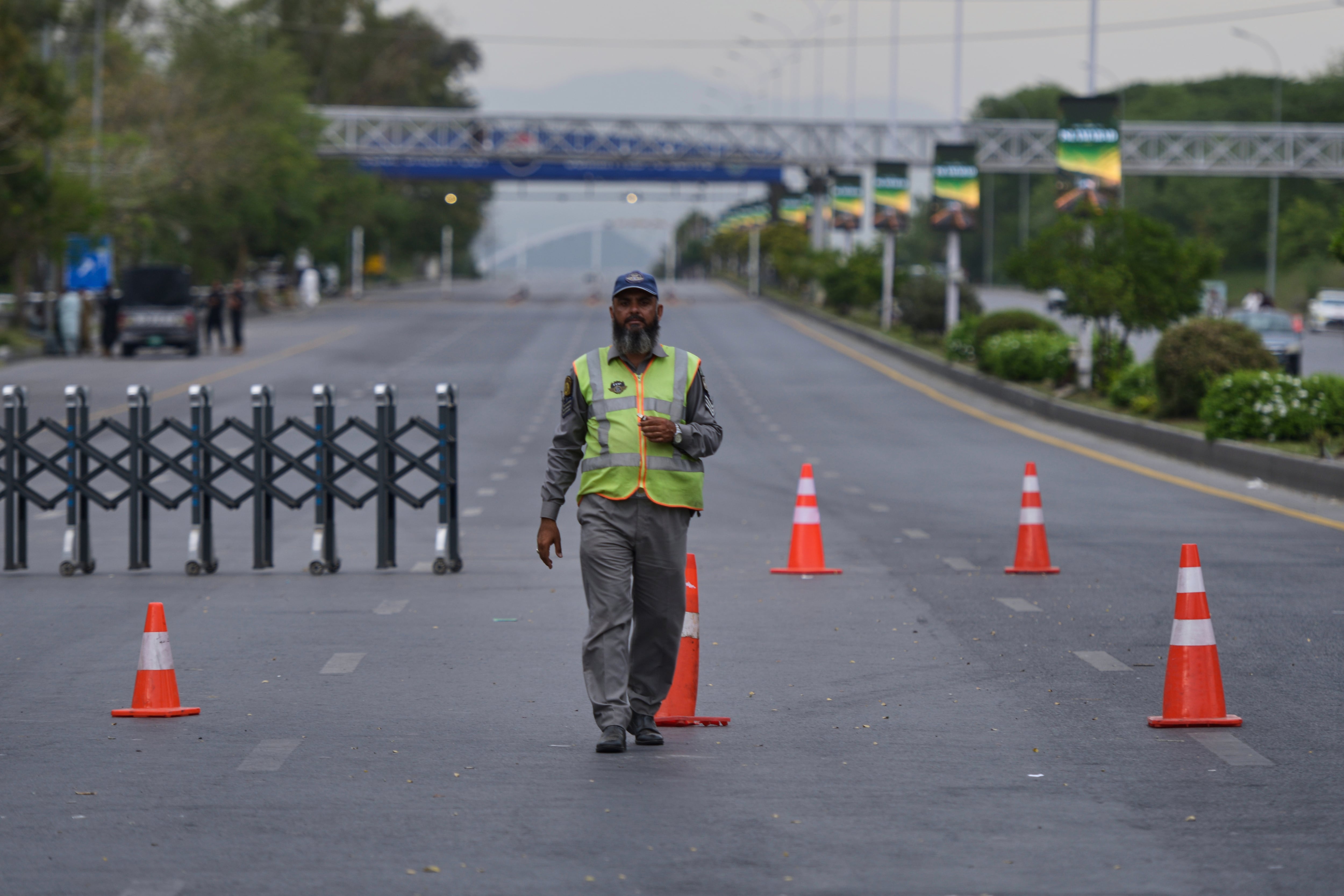 Un agente de policía desvía el tránsito en una calle cortada por las autoridades debido a las medidas de seguridad ante una posible segunda ronda de conversaciones entre Estados Unidos e Irán, en Islamabad, Pakistán.