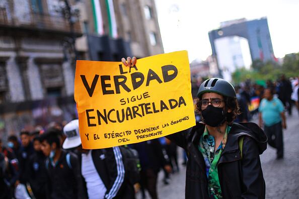 Manifestante sostiene una pancarta durante una manifestación para conmemorar el octavo aniversario de la desaparición de los estudiantes de Ayotzinapa el 26 de septiembre de 2022 en la Ciudad de México, México. El 26 de septiembre de 2014, 43 estudiantes de la Escuela Rural Isidro Burgos de Ayotzinapa desaparecieron en la ciudad de Iguala tras enfrentamientos con fuerzas policiales. Los estudiantes fueron acusados ​​de intentar el secuestro de autobuses para ser utilizados en protestas. (Foto de Manuel Velásquez/Getty Images)