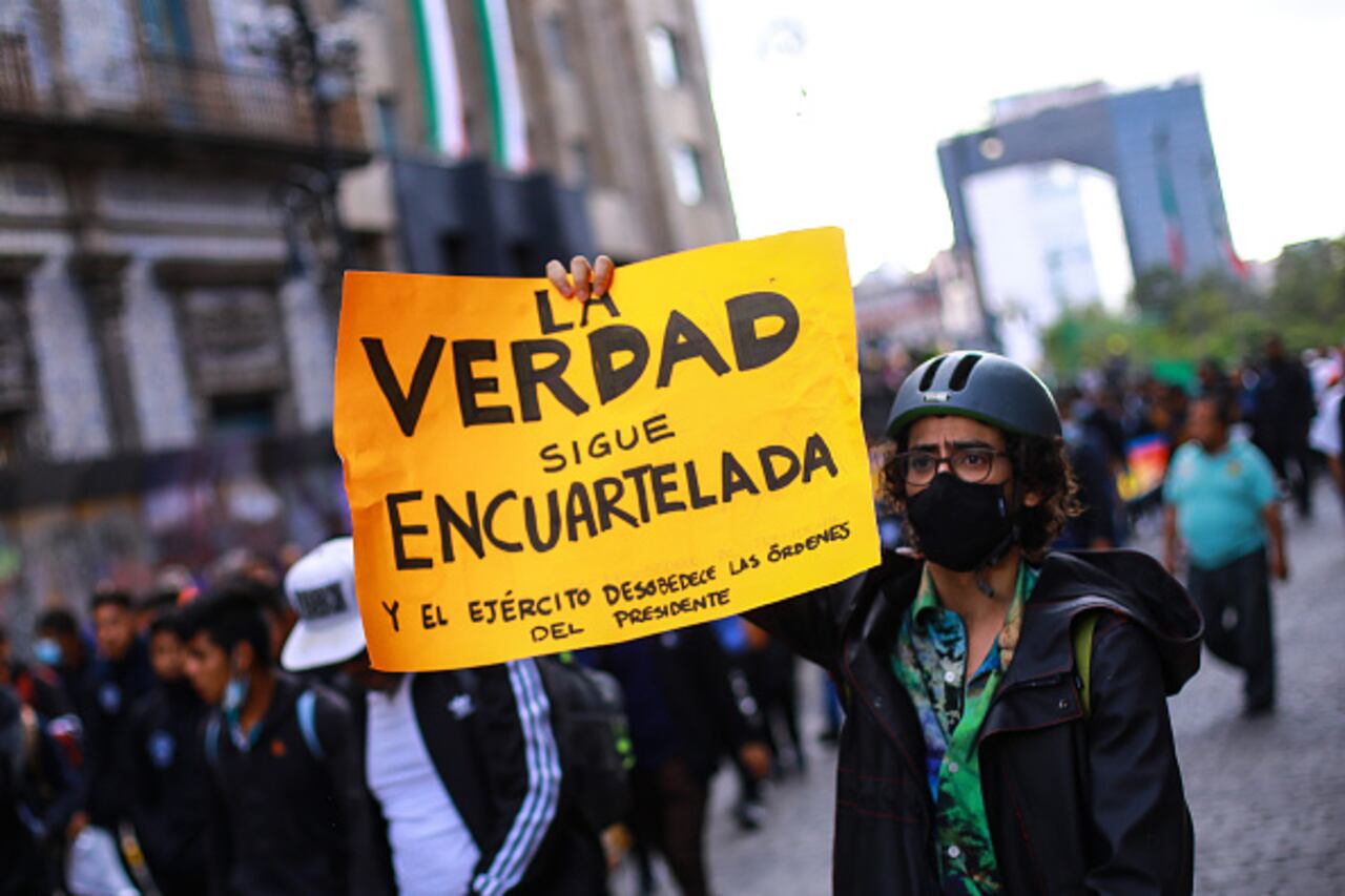 Manifestante sostiene una pancarta durante una manifestación para conmemorar el octavo aniversario de la desaparición de los estudiantes de Ayotzinapa el 26 de septiembre de 2022 en la Ciudad de México, México. El 26 de septiembre de 2014, 43 estudiantes de la Escuela Rural Isidro Burgos de Ayotzinapa desaparecieron en la ciudad de Iguala tras enfrentamientos con fuerzas policiales. Los estudiantes fueron acusados de intentar el secuestro de autobuses para ser utilizados en protestas. (Foto de Manuel Velásquez/Getty Images)
