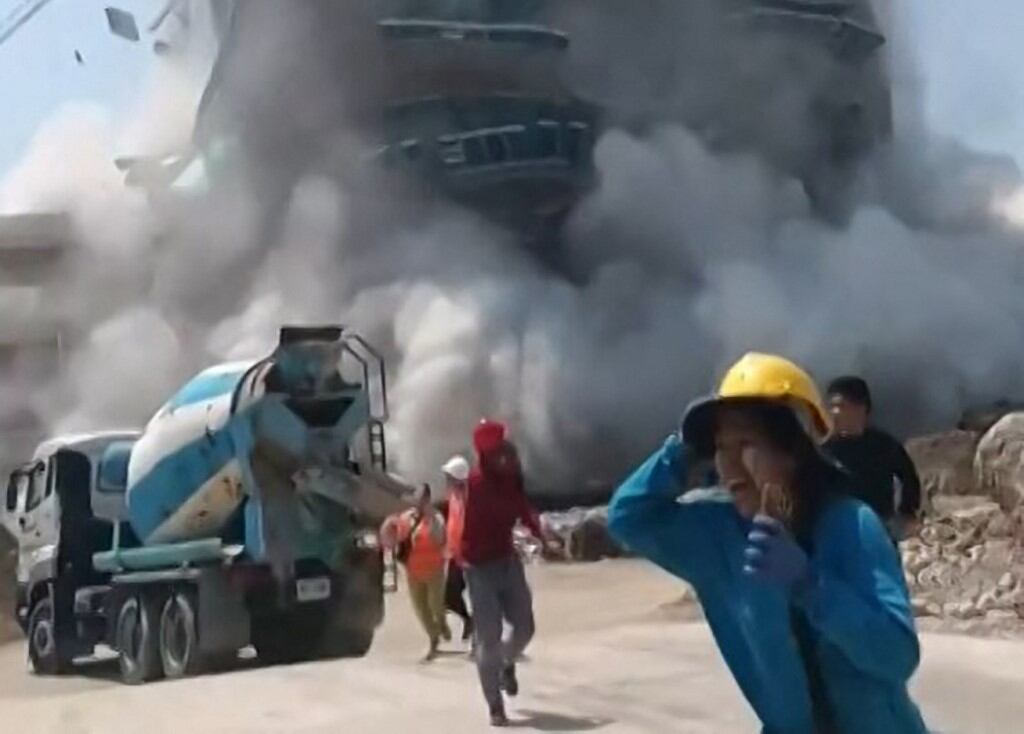 Esta captura de fotograma de un video de UGC tomado y publicado por Khon Su Cheevit Adeet Mai Suay Rok Na en Facebook el 28 de marzo de 2025 muestra a los trabajadores huyendo de un edificio mientras se derrumba en un sitio de construcción en Bangkok, luego de un terremoto (Foto de Handout / Cortesía del usuario de Facebook Khon Su Cheevit Adeet Mai Suay Rok Na / AFP)